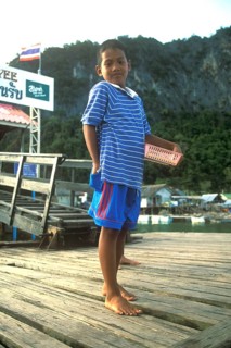 Young boy in the stilt village of Ko Pannyi in Phangnga Bay near Ko Phuket selling souvenirs to