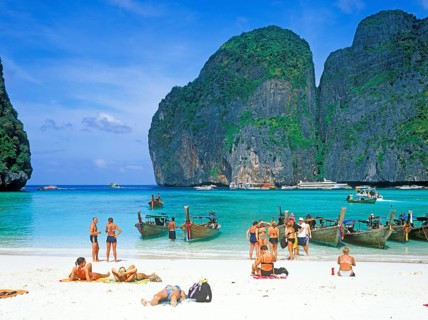 People and longtail boats on Maya Bay beach, known from the movie The Beach, one year in front of