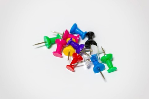 Colourful drawing pins arranged on a neutral background, Germany