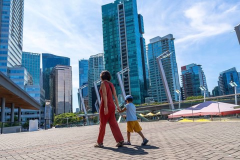 Mother and son holding hands walking in downtown vancouver, british columbia, canada, enjoying a
