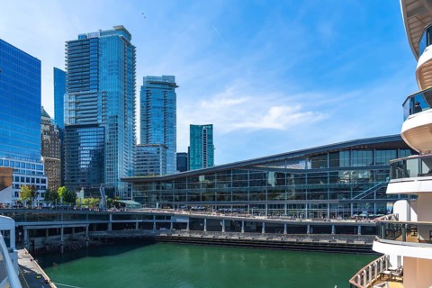 Glass skyscrapers and the vancouver convention centre are reflecting on the green water with a