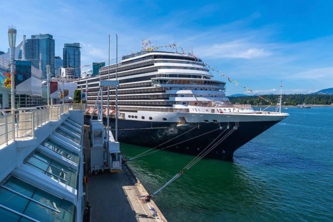 Large cruise ship docking at canada place cruise terminal in vancouver, british columbia, with city