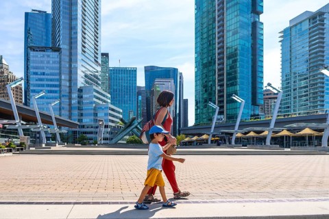 Mother and son enjoying a leisurely stroll through a modern urban square, surrounded by the