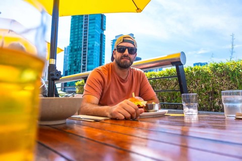 Tourist is having a burger and beer at an outdoor restaurant in vancouver, british columbia, with