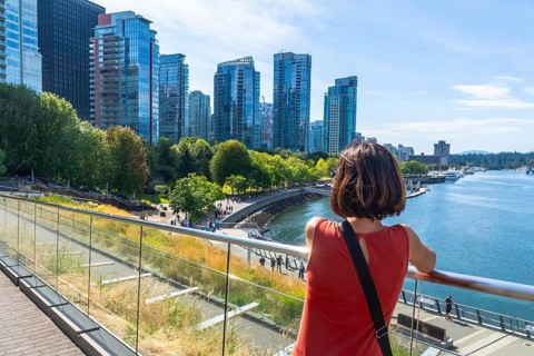 Tourist is enjoying the scenic view of vancouver skyline from david lam park in yaletown,