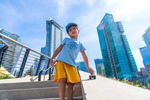 Young child playing joyfully with a toy car on the stairs, soaking up the sun while surrounded by
