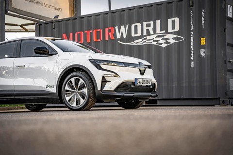 White electric car in front of a black container with Motorworld logo, Deer e-Carsharing, Renault