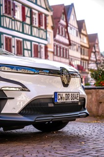 Close-up of a white car with frame houses reflecting on the body, Deer E-Carsharing, Renault