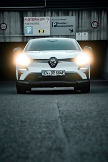 SUV with headlights switched on in front of a parking garage, front view, Deer e-Carsharing,