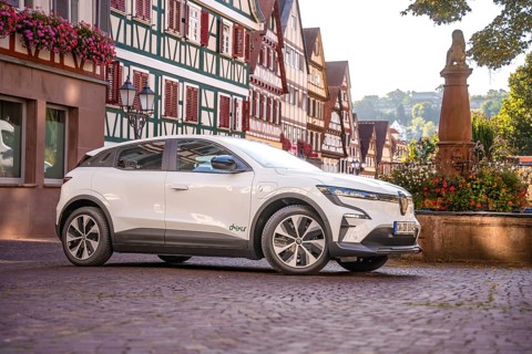 Side view of white car in a historic town with half-timbered houses in summer, Deer e-car sharing,