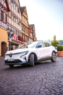Renault Auto drives down the paved street of a historic town, Deer e-Carsharing, Renault Megane,
