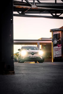 Car in evening lighting on an urban sidewalk surrounded by lanterns, Deer E-Carsharing, Renault