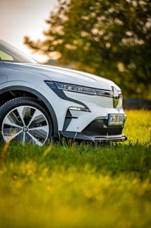 Close-up view of a white car in a meadow, focus on front tires, Deer e-Carsharing, Renault Megane,