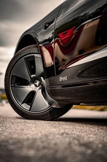 Close-up of a shiny black car with focus on tires, Deer E-Carsharing, Tesla Model 3, Calw, Germany