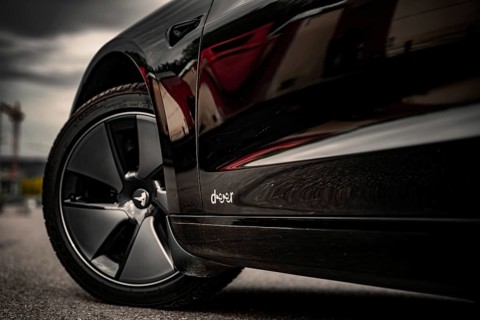 Side view of a black car with emphasis on the rims and tires, Deer E-Carsharing, Tesla Model 3,