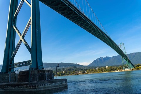Lions gate bridge extending over burrard inlet with cityscape of vancouver and north shore
