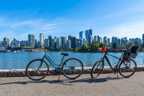 Two bicycles parked along the stanley park seawall overlook vancouver's stunning cityscape,