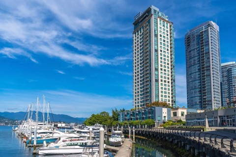 Modern residential skyscrapers rise majestically over the bustling coal harbour marina in vancouver