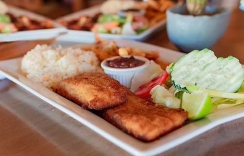 Gourmet food fried fish fillet with salad rice served on wooden table, Close up of fried fish