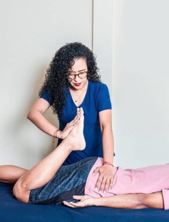 Young woman physiotherapist with lying patient. Physiotherapy rehabilitation concept, Lumbar