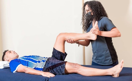 Physiotherapist checking patient leg. Orthopedic specialist helping a patient with a leg injury.