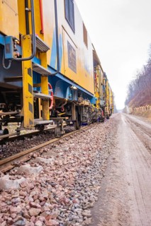 Close-up of gravel tracks with a yellow tool in the background, stuffing machine on Hermann, Hesse,