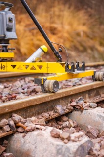 Close-up of a yellow device on railroad tracks in an autumn landscape, stuffing machine on Hermann,