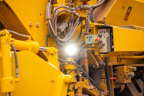 Close-up of yellow machine parts with cables and technical details, tamping machine on Hermann,