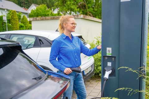 Woman uses charging station for electric cars in a municipal parking lot, Deer e-Carsharing, Calw,