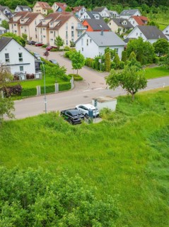 Aerial view of a residential area with adjacent road and lots of greenery, Deer E-Carsharing, Calw,