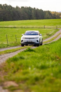 SUV on dirt road through green fields, peaceful natural scenery, deer e-car sharing, VW ID4, Calw,
