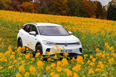 A white car drives through a blooming yellow field in autumn, Deer E-Carsharing, VW ID4, Calw,