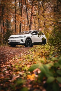 SUV in an autumn-colored forest on a narrow path, Deer E-Carsharing, VW ID4, Calw, Germany