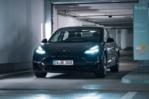 Black car drives into a modern, well-lit garage with cool atmosphere, Deer E-Carsharing, Tesla