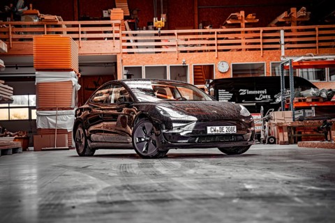 Tesla in a workshop with industrial elements and a building atmosphere, Deer e-Carsharing, Tesla