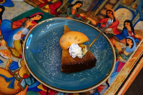 Piece of cake decorated with a mango slice served in a Persian café, Fürth, Middle Franconia,