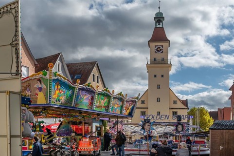 Children's carousel at the town festival on the market square, in the back the town hall, building