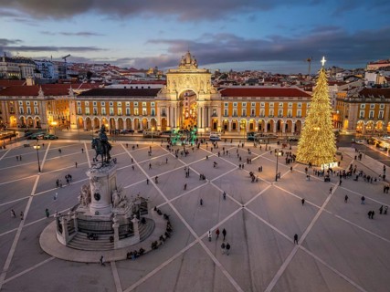 Praca do Comercio glows in the evening with a decorated Christmas tree and festive lights, creating
