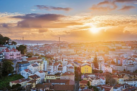 Stunning sunset over Lisbon at Miradouro da Senhora do Monte, with views of Carmo Convent and the