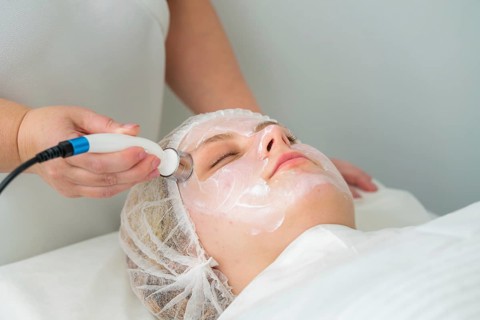 Client relaxes as a specialist applies a metallic applicator during RF lifting, promoting skin