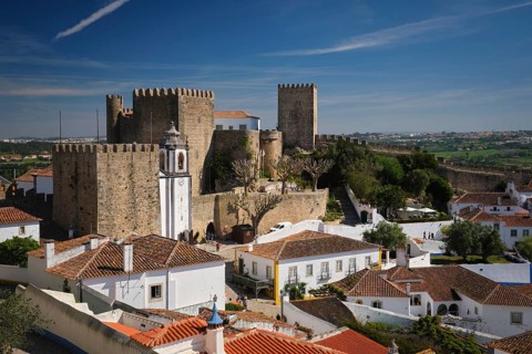 Visit the historic Obidos town where the medieval castle overlooks charming old houses under a