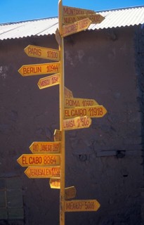 International guide on Isla Taquile in Lake Titicaca shows the distances to cities around the
