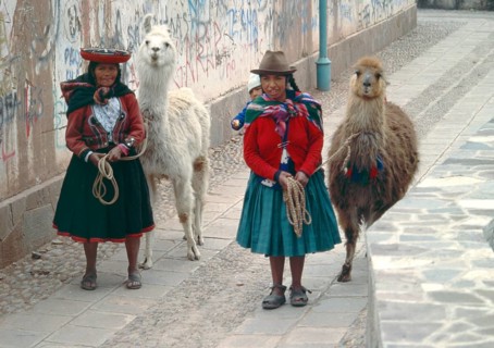 Traditionally dressed woman with llamas and small children in Cusco, Peru, Andean Highlands, South