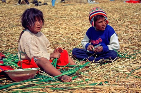 Children sitting on a floating Uro island in Lake Titcaca, Peru, South America, September 1997,