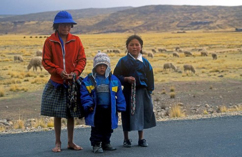 Children sell cheap jewelry on the roadside near Puno, Andean Highlands, Peru, South America,