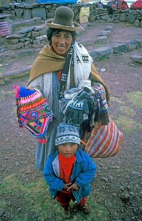 A woman with a small child sells souvenirs to tourists at the Sillustani ruins on Lake Umayo near