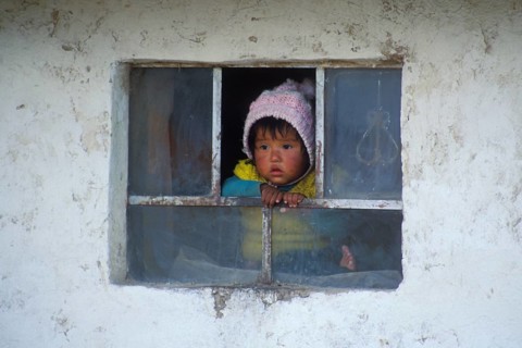 Little child looking out of a window near Cusco, Andean Highlands, Peru, South America, September
