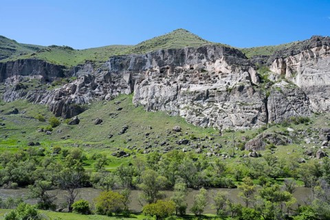 Green hills and imposing cliffs with picturesque skies. Pristine natural scenery, cave town, cave