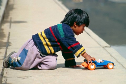 Little boy playing with toy car, Puno, Andean Highlands, Peru, South America, September 1997,