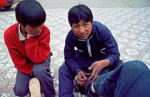 Teenager, young shoe cleaner at work, Puno on Lake Titicaca, Andean highlands, Peru, South America,